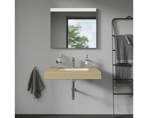 Salle de bains avec lavabo, miroir et porte-serviettes pour une atmosphère organisée et lumineuse.