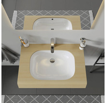 Meuble-lavabo avec vasque à poser, robinetterie, miroir et accessoires de salle de bain dans une salle de bain lumineuse