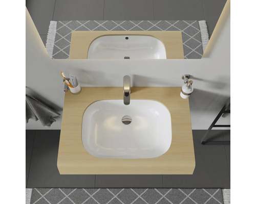 Meuble-lavabo avec vasque à poser, robinetterie, miroir et accessoires de salle de bain dans une salle de bain lumineuse