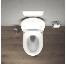 Photo de toilettes blanches avec réservoir de chasse d'eau et porte-papier toilette dans la salle de bains.