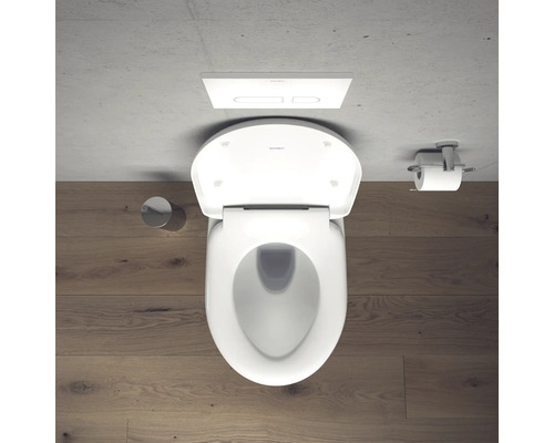 Photo de toilettes blanches avec réservoir de chasse d'eau et porte-papier toilette dans la salle de bains.