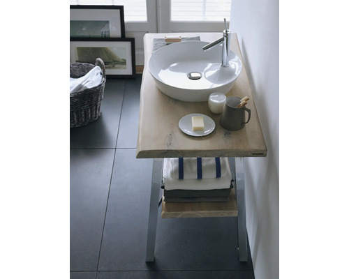 Meuble de salle de bains avec vasque à poser, robinetterie et serviettes.