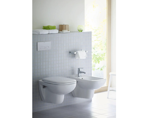 Salle de bains moderne avec WC suspendu et bidet devant un mur carrelé.