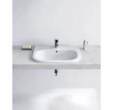 Lavabo en céramique avec robinet sur un meuble sous-lavabo dans la salle de bain.