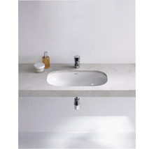 Salle de bains moderne avec lavabo à poser, robinet et produits de soin sur une étagère.