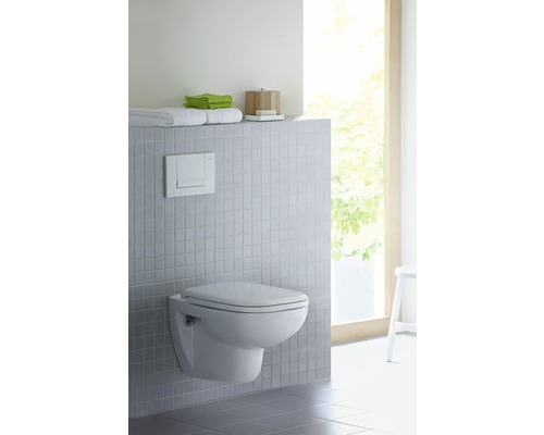 Salle de bains moderne avec WC suspendu, réservoir de chasse et espace de rangement pour les serviettes et accessoires de bain.