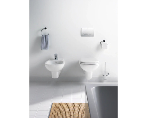 Salle de bain avec bidet, toilettes, porte-serviettes et tapis de bain