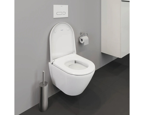 WC suspendu à fond creux avec bride ouverte, brosse de toilette et plaque de commande dans une salle de bains moderne