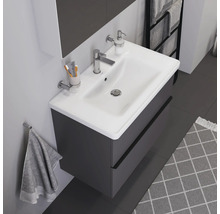 Waschtisch mit Unterschrank, Armatur, Seifenspender, Handtuch und Teppich in einem Badezimmer