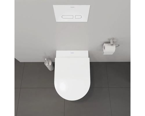 Vue de dessus de toilettes avec réservoir de chasse d'eau, brosse de toilette et porte-papier toilette.