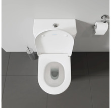 Vue de dessus de toilettes avec distributeur de papier toilette et brosse de toilettes