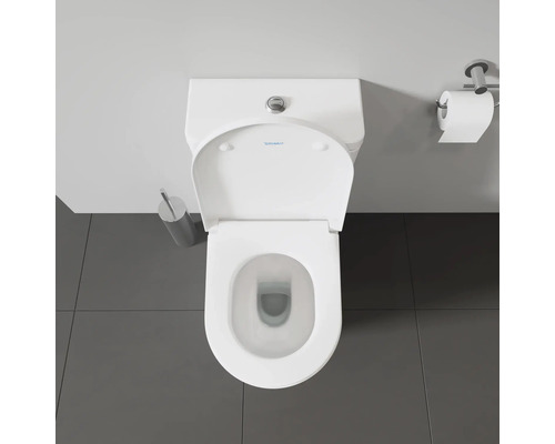Vue de dessus de toilettes avec distributeur de papier toilette et brosse de toilettes