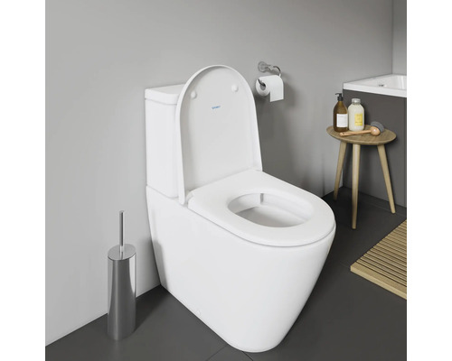 WC au sol blanc avec couvercle de toilette ouvert dans la salle de bain