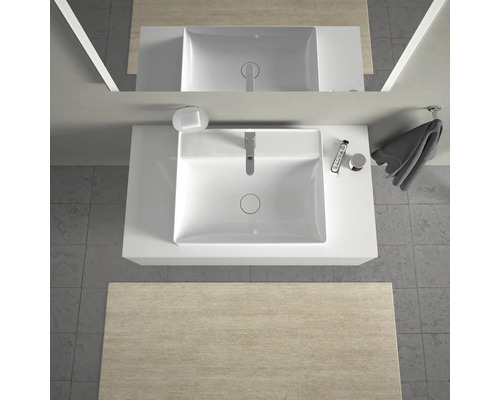 Vue de dessus d'une salle de bains avec lavabo, robinet, savon, serviette et produits cosmétiques