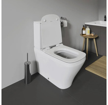 WC au sol blanc avec couvercle ouvert dans une salle de bain