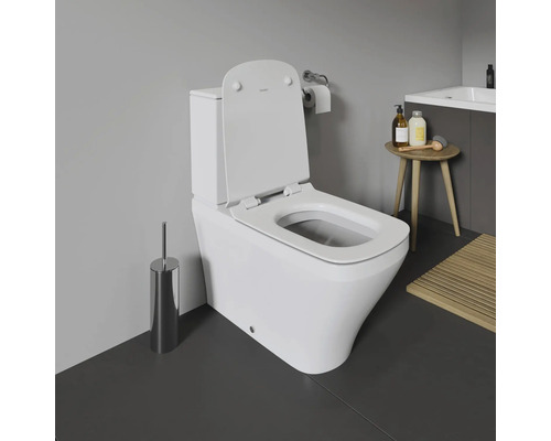 WC au sol blanc avec couvercle ouvert dans une salle de bain