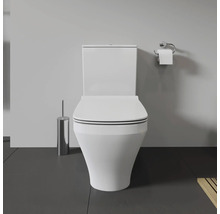 Toilettes blanches avec brosse de toilette et support papier toilette dans la salle de bain