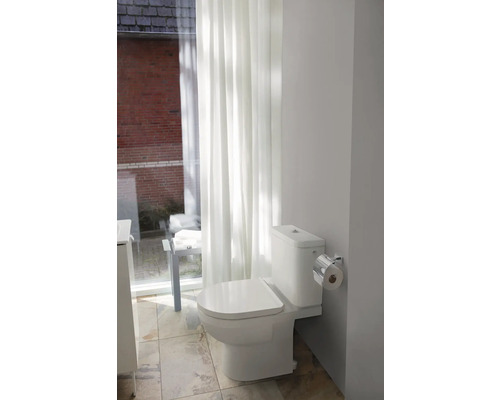Toilettes dans une salle de bains avec rideaux et carrelage