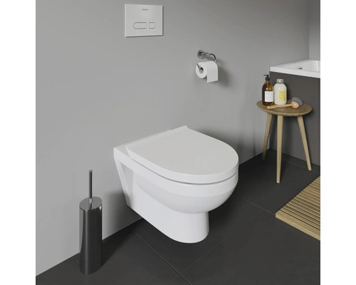 WC suspendu dans une salle de bains avec brosse de toilette, porte-papier toilette et petite table