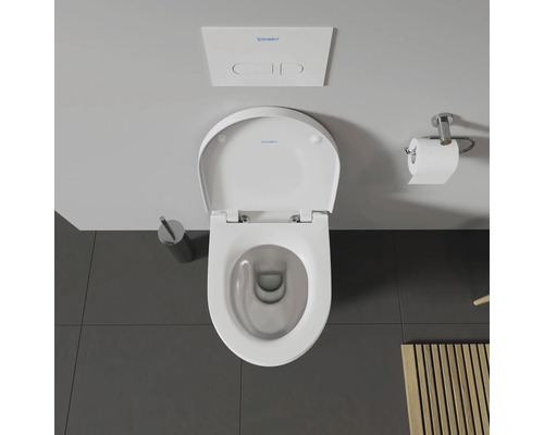 Vue de dessus de toilettes avec réservoir de chasse, brosse de toilettes et porte-papier toilette