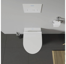 Vue de dessus de toilettes avec distributeur de papier toilette, brosse de toilette et réservoir de chasse d'eau