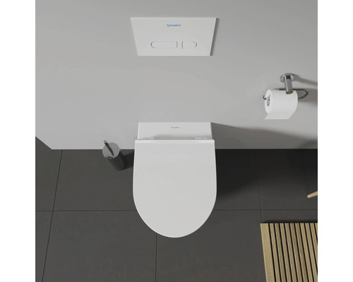 Vue de dessus de toilettes avec distributeur de papier toilette, brosse de toilette et réservoir de chasse d'eau