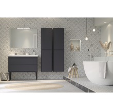Salle de bains moderne avec lavabo, miroir, armoires hautes et baignoire îlot devant un mur carrelé en forme de coquillage
