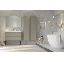 Salle de bain lumineuse avec meuble-lavabo, miroir, armoire haute et baignoire îlot devant un mur carrelé