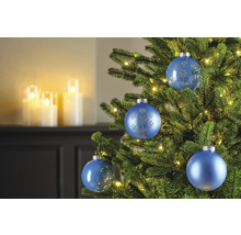 Nahaufnahme von blauem Christbaumschmuck an einem Weihnachtsbaum mit Lichtern