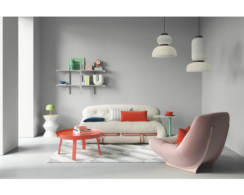 Salon lumineux avec canapé, fauteuil, table et étagères