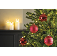 Gros plan d'un sapin de Noël décoré avec des boules de Noël rouges et des lumières