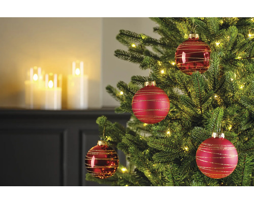 Gros plan d'un sapin de Noël décoré avec des boules de Noël rouges et des lumières