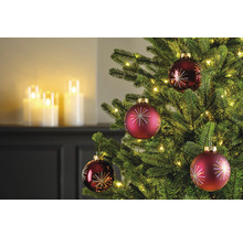 Gros plan d'un arbre de Noël avec des boules de Noël rouges et des lumières