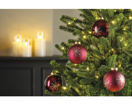 Gros plan d'un arbre de Noël avec des boules de Noël rouges et des lumières