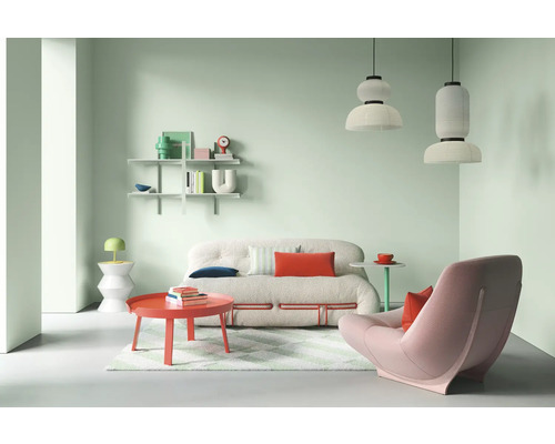 Heller Wohnraum mit Sofa, Sessel, Tisch und Regalen