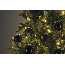 Nahaufnahme eines Weihnachtsbaums mit schwarzen Christbaumkugeln und Lichterkette