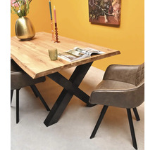 Coin repas moderne avec une table en bois massif, un piètement en X en métal noir et deux chaises rembourrées grises avec accoudoirs.