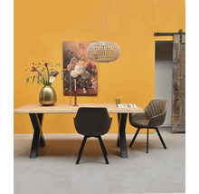 Salle à manger moderne avec table en bois, structure en métal, chaises rembourrées, suspension, décoration florale et porte coulissante.