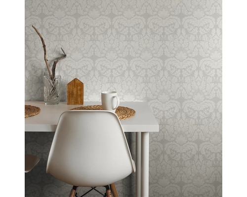 Scène avec papier peint à motifs, table, chaise, tasse et décoration, qui montre une ambiance lumineuse et organisée