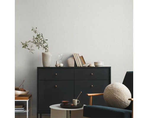 Salon avec commode, fauteuil et papier peint à motifs