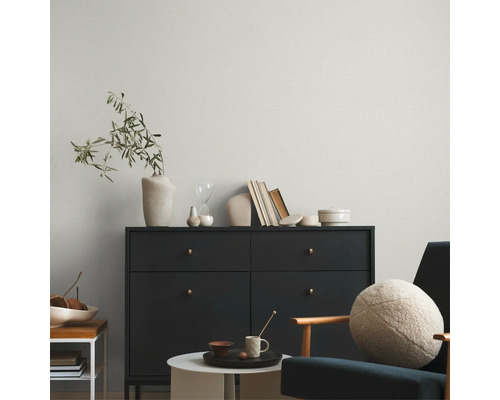 Wohnzimmer mit Kommode, Dekorationsgegenständen und Sessel