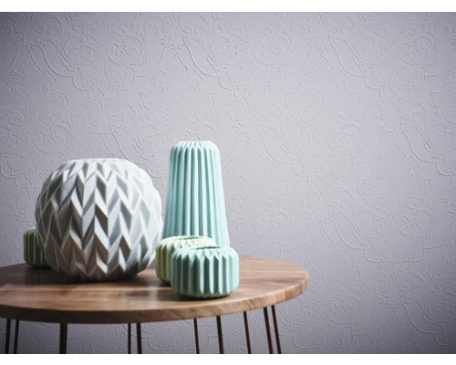 Vases décoratifs sur une table en bois devant un papier peint à motifs