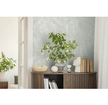 Dekoratives Interieur mit gemusterter Tapete, Kommode, Pflanzen und dekorativen Elementen.