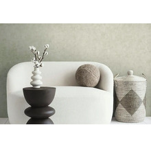 Dekoratives Wohnambiente mit Sofa, Beistelltisch, Vase mit Baumwollzweigen, Kissen und Aufbewahrungskorb