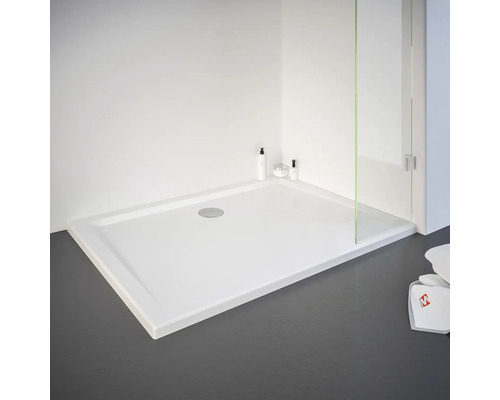 Receveur de douche rectangulaire avec design plat et bonde centrale dans un environnement de salle de bain lumineux.
