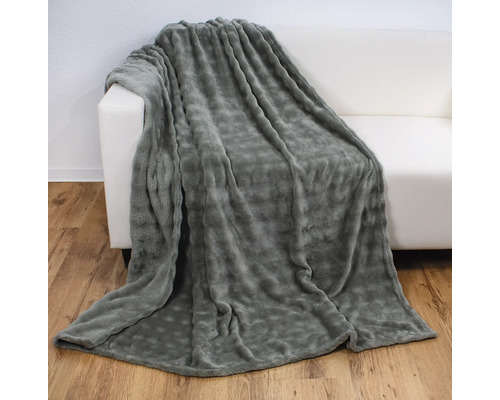 Couverture grise en molleton sur un canapé blanc