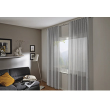 Salon avec rideaux, canapé et lampadaire pour une ambiance chaleureuse