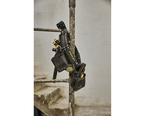 Sacoche à outils Stanley avec divers outils accrochée à une barre.