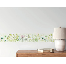 Wandbordüre mit Blumenmuster im Interieur über Kommode, Lampe und Buch