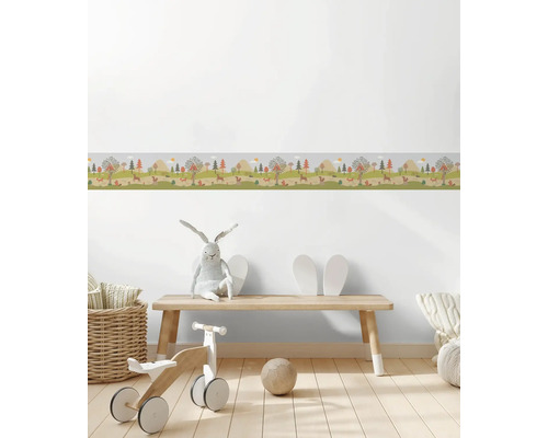 Kinderzimmer mit Waldtiere-Bordüre an der Wand, Holzbänken und Spielzeugen